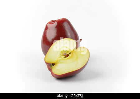 One and a half red apples on off-white background Stock Photo