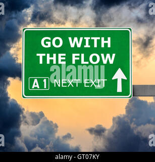 GO WITH THE FLOW road sign against clear blue sky Stock Photo
