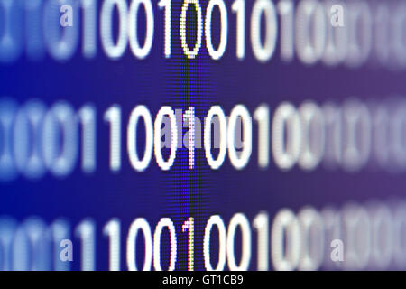 Binary code on a computer monitor blurred background Stock Photo