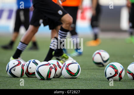Thessaloniki, Greece - June 24, 2016: Soccer ball in the foreground and legs players in backraount in training of team Paok Stock Photo