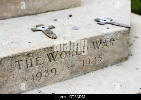 Old weathered stone war memorial with aged wooden crosses in a small village in the UK. Stock Photo