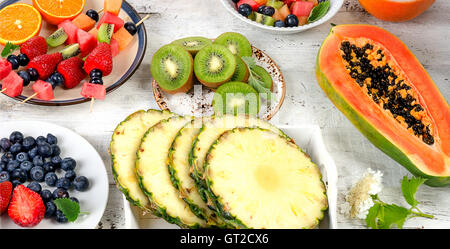 Preparing  fresh fruit salad on white wooden  background. Top view Stock Photo