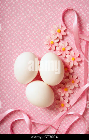 three white eggs with decoration on pink, Easter cocnept Stock Photo