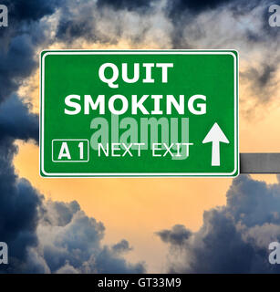 QUIT SMOKING road sign against clear blue sky Stock Photo