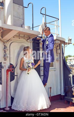 Beautiful wedding couple posing on the boat Stock Photo