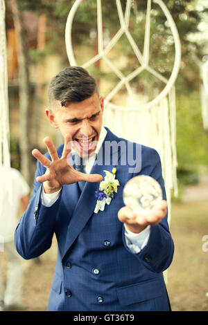 Groom holding a crystal ball and casts  spell. Stock Photo