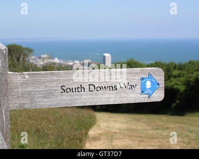 Engraved wooden signpost on South Downs Way with town of Eastbourne in distance Stock Photo