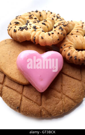 Sweet red marzipan heart and Crunchy fresh biscuits on a white background Stock Photo