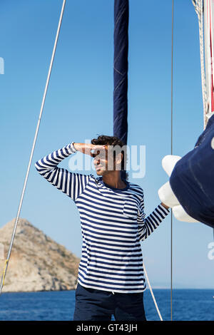 Young man on a sailing ship looks into the distance Stock Photo