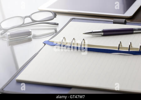 Blank note paper with pen, digital table and glasses. Theme business meeting concept. Warm tone. Stock Photo