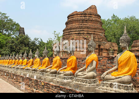 Aligned buddha statues with orange bands in Ayutthaya, Thailand Stock Photo