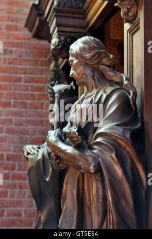 Rich wooden decor of confessional in St. Michiels church in Ghent, Belgium, on July 19, 2016 colored with sun beams from stained Stock Photo