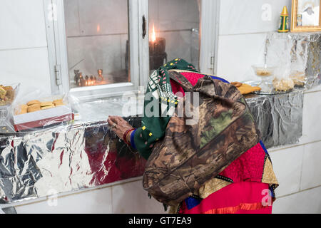 Shenananou Kanjani worships before the Atash Bahram, meaning “Victorious Fire”, dated to 470 AD  with Zoroastrian symbols. Stock Photo