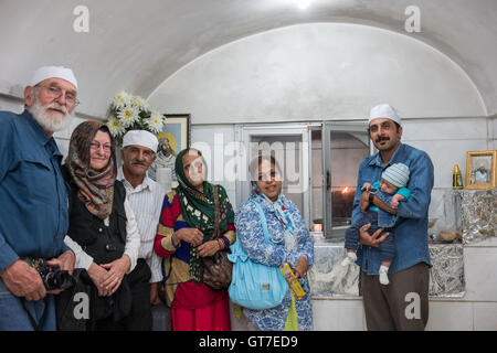 Kanjani family with Tom and Tina before the Atash Bahram, meaning “Victorious Fire”, dated to 470 AD  with Zoroastrian symbols. Stock Photo