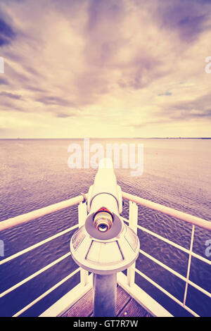 Retro toned picture of a telescope pointed at horizon, shallow depth of field, future concept. Stock Photo