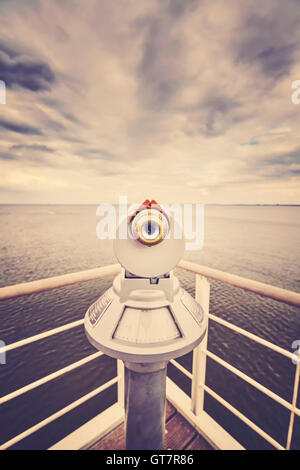 Retro toned picture of a telescope pointed at horizon, shallow depth of field, future concept. Stock Photo