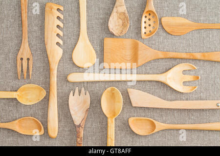 Assorted set of wooden kitchen utensils in an overhead background view with spoons, ladles, pasta drainer, salad servers and dra Stock Photo