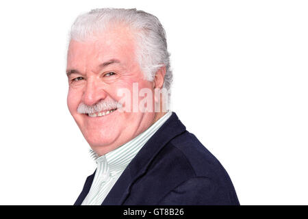 Charismatic happy attractive senior man with a lovely warm smile turning to look at the camera with an amused expression, on whi Stock Photo