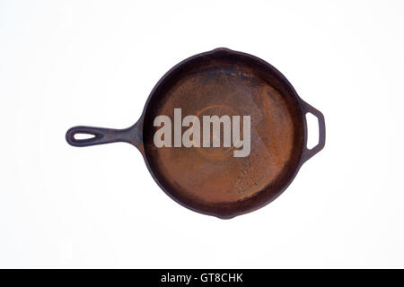 Old rusty round black cast iron frying pan viewed from above isolated on a white background centered in the frame Stock Photo