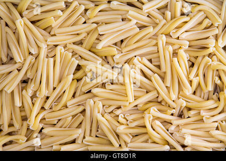 Background texture of dried Italian casarecce, a tubular regional pasta from the island of Sicily made from durum wheat dough us Stock Photo