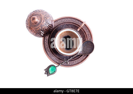 Cup of freshly brewed hot frothy Turkish coffee served in a traditional cup with lid with a decorative teaspoon, overhead view i Stock Photo