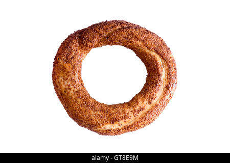 Freshly baked crispy golden Turkish simit, a traditional circular bread with sesame seeds served with Turkish tea, isolated Stock Photo