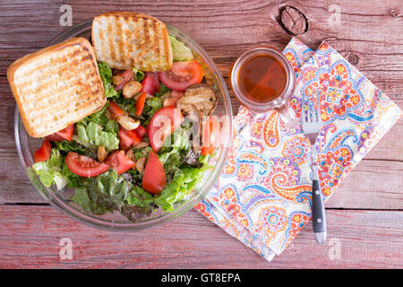 Healthy mixed leafy green salad with lettuce, tomato, garlic, sesame and bell peppers served with grilled toast and freshly brew Stock Photo