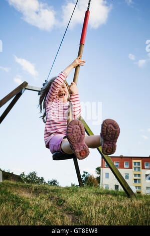 5 year old girl playing with a zip line on a sunny evening, Germany Stock Photo