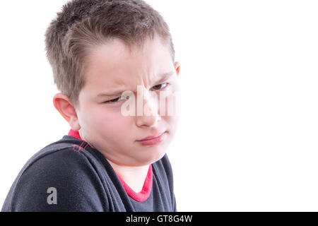 Head and Shoulders Close Up Portrait of Young Boy with Scrutinizing Facial Expression Glaring at Camera in Studio with White Bac Stock Photo