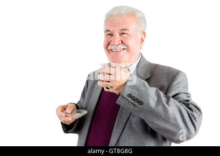 Half Body Shot of a Smiling Middle Aged Businessman, Holding a Turkish Tea While Looking Out Against White Background. Stock Photo