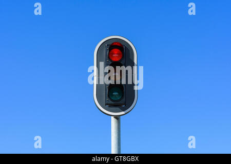 Red Traffic Light Against Blue Sky, Denmark Stock Photo