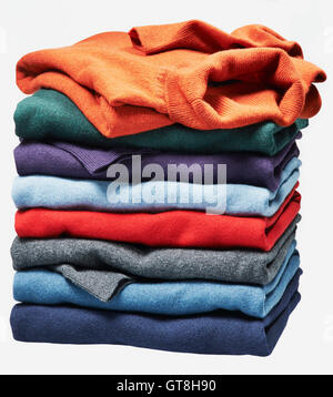 Stack of different coloured sweaters on white background Stock Photo