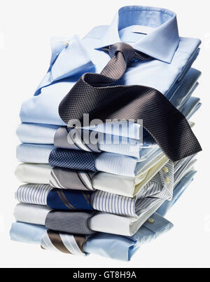 Stack of multi coloured shirts with ties on white background Stock Photo