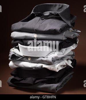 Stack of men's dress shirts on brown background Stock Photo