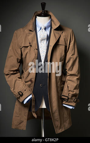 Brown trench coat with suit jacket, shirt and tie on a bust, studio shot Stock Photo