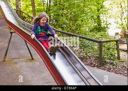 5 year old girl having fun on a slide at a playground, Germany Stock Photo