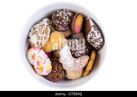 Tasty selection of crunchy cookies in a white bowl or jar decorated with glazing and sprinkles in different shapes, overhead vie Stock Photo