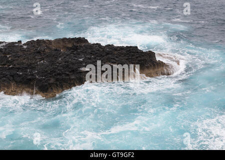 Ocean waves crashing against rock Stock Photo