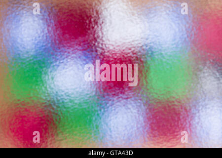 Abstract festive colorful Christmas background of an arrangement of multicolored gift boxes behind frosted glass in a full frame Stock Photo