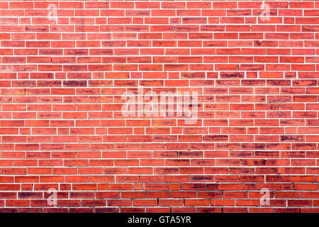 Bright red brick wall background with dark stains and copy space for concept about inner city or urban lifestyle Stock Photo