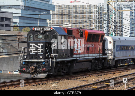 An Metro-North BL20GH diesel locomotive in New Haven livery pulls a short train into Stamford Station in Stamford, Connecticut. Stock Photo