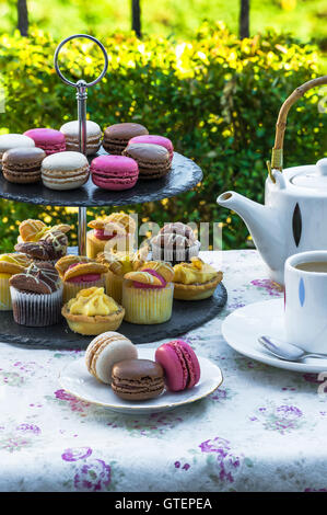 Tea with cakes and macaroons set up on the table in the garden