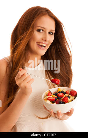 healthy eating  - woman eats a bowl of fruit salad isolated over white background - vegetarian meal Stock Photo