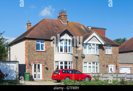 1930s typical British 2 floor semi detached brick house with bow windows and a sloping tiled roof, in Southern England, UK. Stock Photo