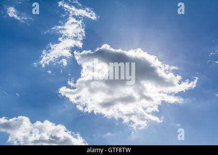 Sun hiding beyond the clouds on a bright summers day. Stock Photo