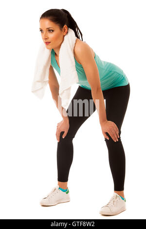Woman rests after fitness workout with towel around her neck isolated over white background Stock Photo