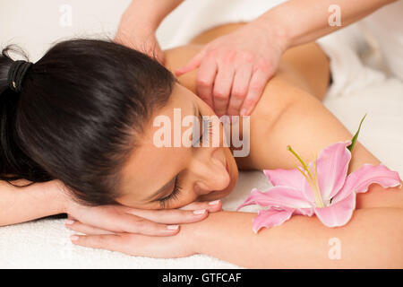 Beautiful young woman having a rejuvenating massage in a wellness studio - spa Stock Photo