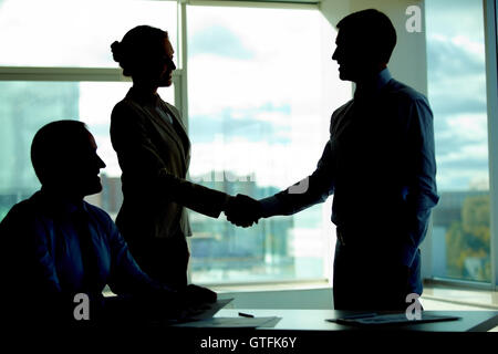 Handshake in the dark Stock Photo
