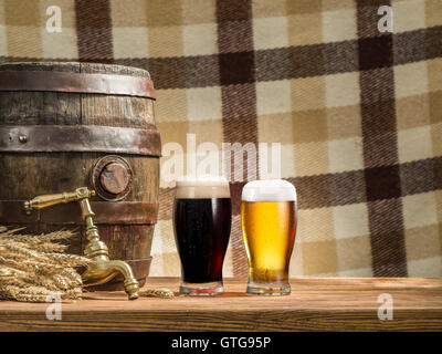 Glasses of  beer and ale barrel on the wooden table. Craft brewery. Stock Photo