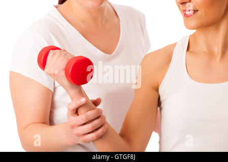 Physiotherapy - therapist doing arm  excercises with dumbbells for improving arm strenght and coordination  with a patient to re Stock Photo